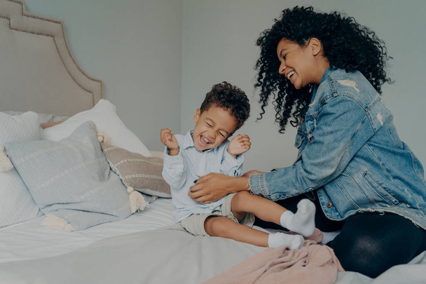 mujer afroamericana divertirse con poco adorable hijo en casa - Foto, Imagen
