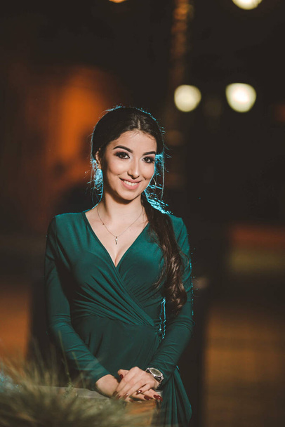 A pretty Caucasian lady with a green evening dress posing in the street - Foto, Imagen