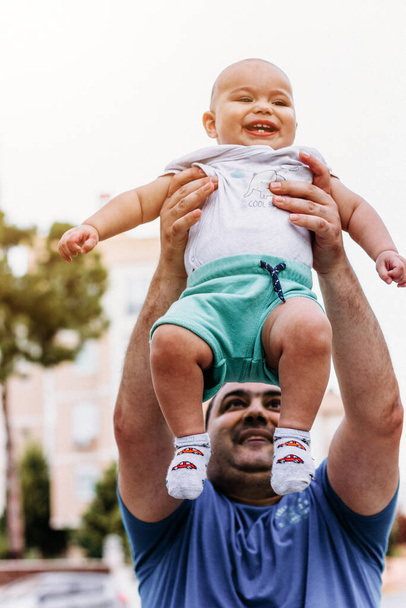 Padre jugando con su bebé. Papá lanza al hijo al aire. - Foto, Imagen