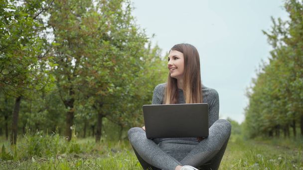 Informatikai specialista, aki a szabadban dolgozik. Nők folytatnak üzleti vagy szabadúszó a természetben, vagy friss levegőt csodálatos napfény. Lány ül a parkban vagy erdőben, nyitó laptop a természetben. - Fotó, kép