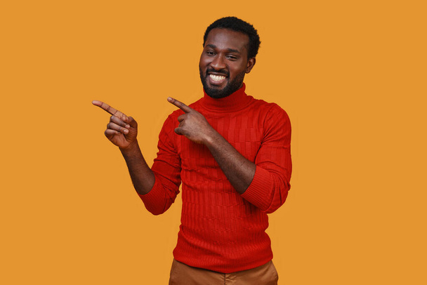 Handsome young African man in casual clothing gesturing and smiling - Photo, image