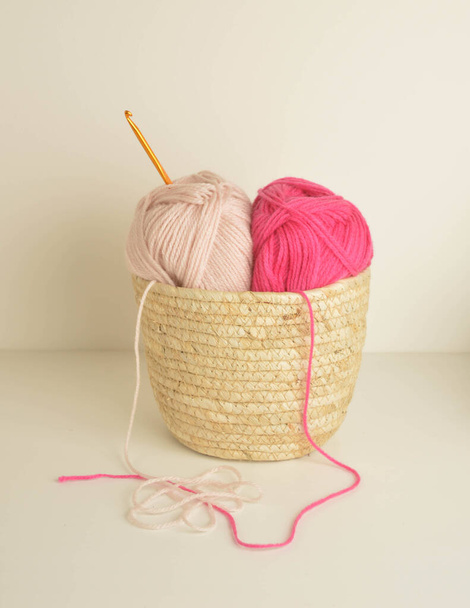 розовые и мягкие пастельные шерстяные шарики в корзине с крючком - Фото, изображение