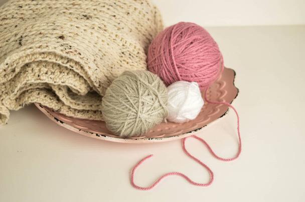 Women's hobby. Crochet and knitting. Yarns in basket on pink palka dot  background, crocheting supplies. Stock Photo