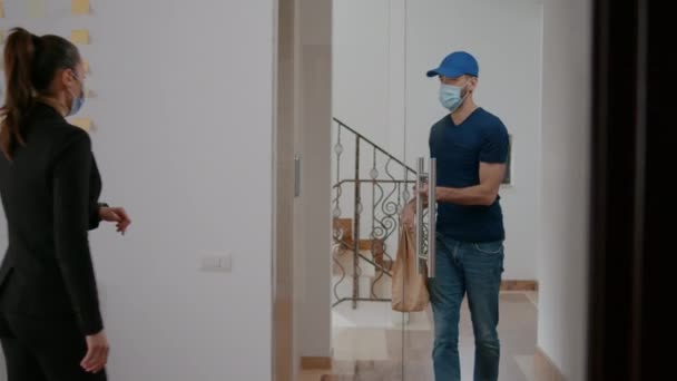 Leverancier met medisch gezichtsmasker en handschoenen tegen coronavirus leveren afhaalmaaltijden - Video