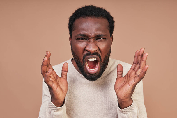 Angry young African man in casual clothing screaming and looking at camera - Fotoğraf, Görsel