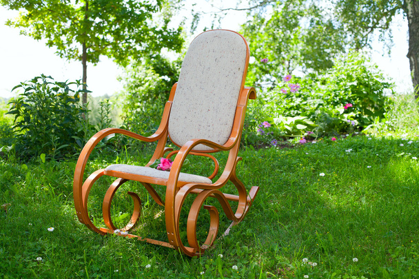rocking chair with pink rose in spring garden - Фото, изображение