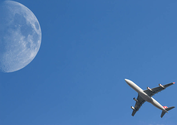 Uçak gökyüzünde büyük bir ay ile havalanıyor. - Fotoğraf, Görsel