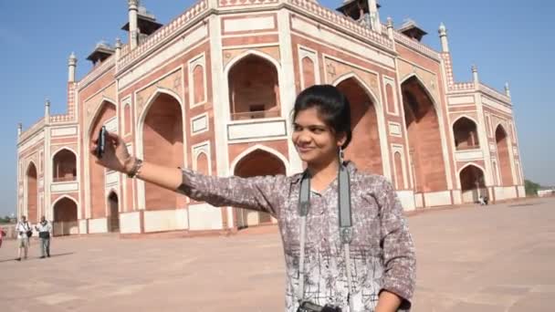 Jovencita tomando en la Tumba de Humayun. La Tumba de Humayun es uno de los monumentos más famosos de Delhi, India - Metraje, vídeo