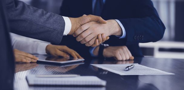 Handshake as successful negotiation ending, close-up. Unknown business people shaking hands after contract signing in modern office - Photo, Image