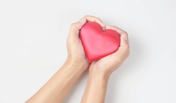 A kezek vörös szívet tartanak. szív-egészségügyi adományozási koncepciók - Fotó, kép