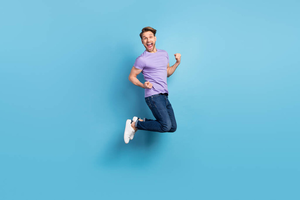 Full length body photo of young man jumping high gesturing like winner isolated on pastel blue color background - Φωτογραφία, εικόνα
