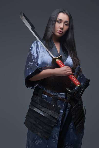 Samurai hembra sosteniendo katana en su hombro - Foto, imagen