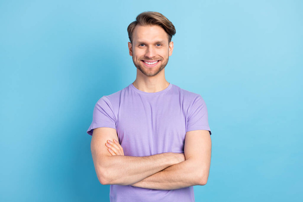 Photo portrait of young man with folded hands smiling isolated on pastel blue color background - Foto, afbeelding