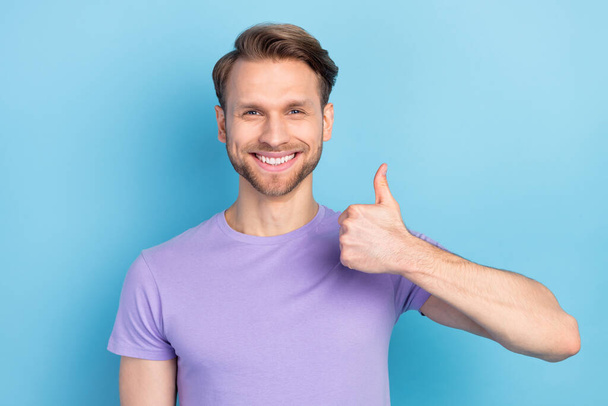 Zdjęcie zadowolonego wesołego człowieka promieniejący uśmiech pokazać kciuk do góry wygląd aparat odizolowany na niebieskim tle koloru - Zdjęcie, obraz
