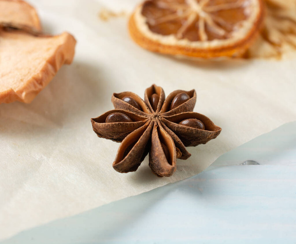 dried round slices of lemon and apple as well as star anise on a blue background. close-up. - Photo, Image