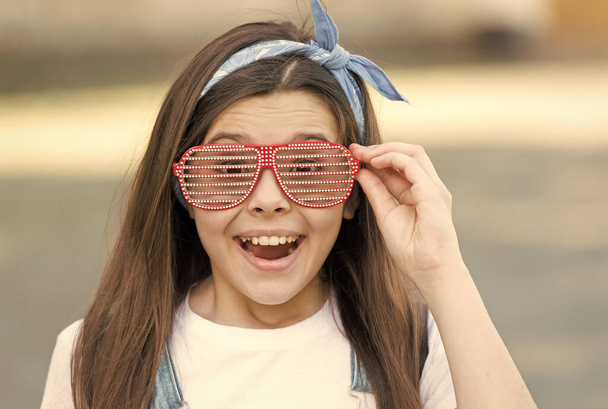 My favorite accessory. Happy girl wear fancy glasses outdoors. Fashion accessory. Little child with party look. Trendy accessory for partying. Designer eyewear. Accessory for your face - Photo, Image