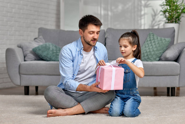 daughter congratulates father and gives him gift box. - Photo, image