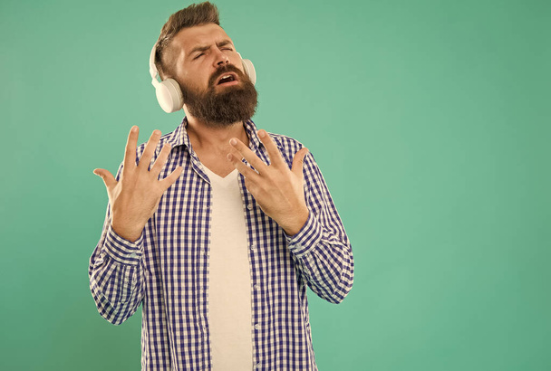 inspired caucasian guy with beard and mustache enjoy music in digital earphones - Foto, afbeelding