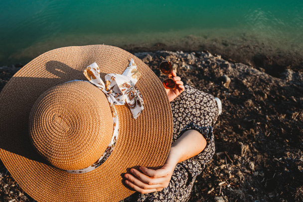 woman holding summer hat and glasses on the beach top view - 写真・画像