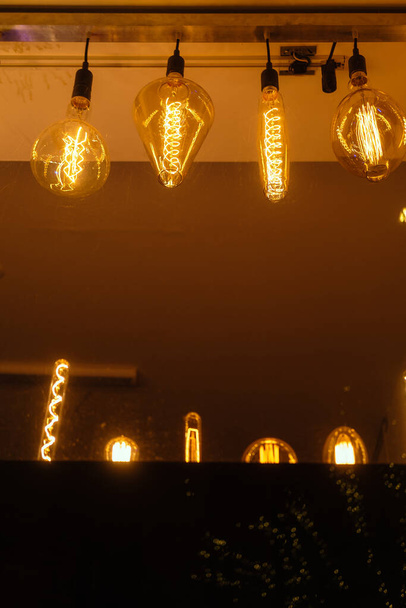 Farklı elektro-gerici lambalardan oluşan sıra. Karanlık arka plan. Sıcak sarı ışık - Fotoğraf, Görsel