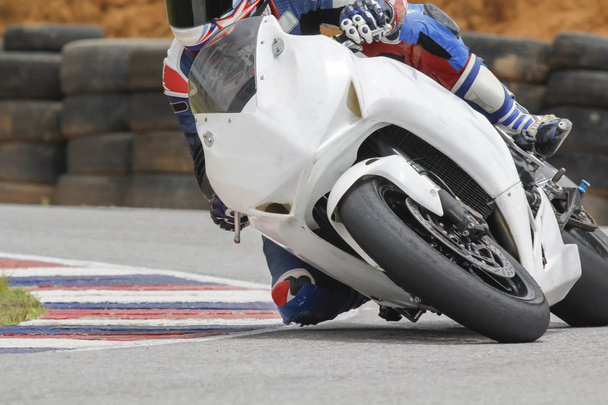 Racing bike rider leaning into a fast corner on track - Photo, Image