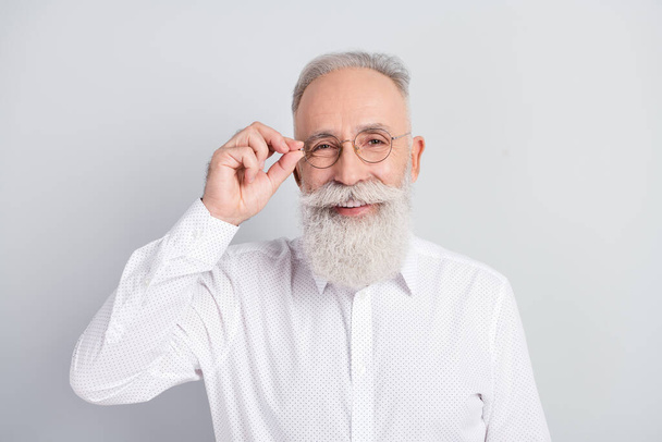 Photo of handsome cheerful grey hair old man touch spectacles wear white shirt isolated on grey color background - Photo, image