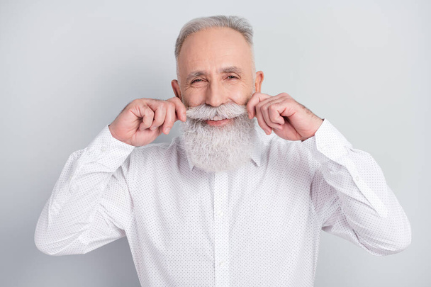 Photo of elegant charming positive old man hold fix mustache smile good mood isolated on grey color background - Foto, Imagem