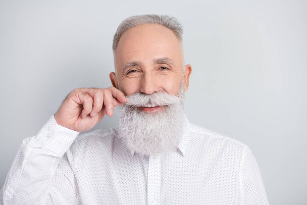Photo of charming cheerful old man fix mustache smile good mood happy face isolated on grey color background - 写真・画像