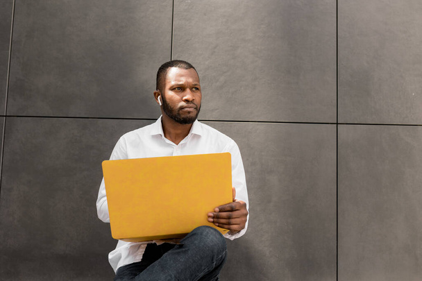 african american man with laptop near wall  - Фото, зображення