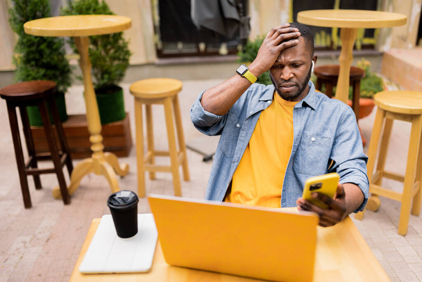 african american man with laptop and coffee cup on the table - Foto, afbeelding