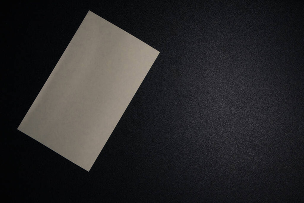 Notepad on a black table with light. - Zdjęcie, obraz