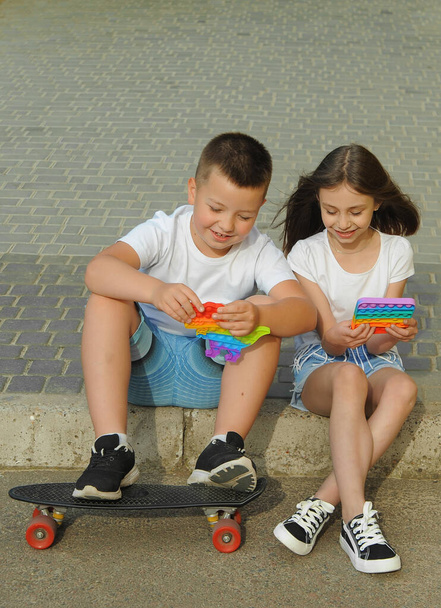 Niños felices juegan con pop al aire libre. - Foto, imagen