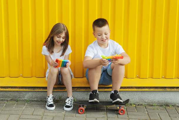 Happy children plays with pop it outdoors. - Photo, Image