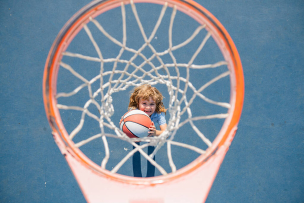 Angle view from on top of kid playing basketball on playground. - Φωτογραφία, εικόνα