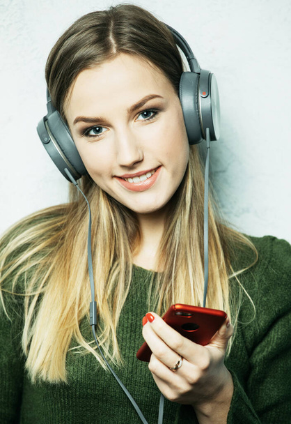 people and technology concept - happy young woman in headphones listening to music from smartphone - Фото, зображення