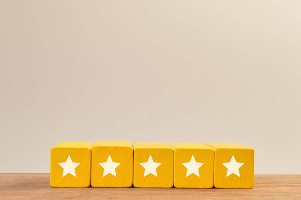 Holzblöcke mit Fünf-Sterne-Symbolen. Exzellente Bewertung der Kundenzufriedenheit durch Unternehmensdienstleistungen - Foto, Bild