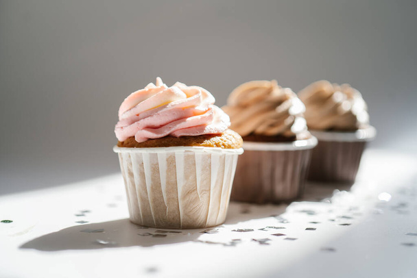 Cupcakes on a white sunny background with a shadow. - Zdjęcie, obraz