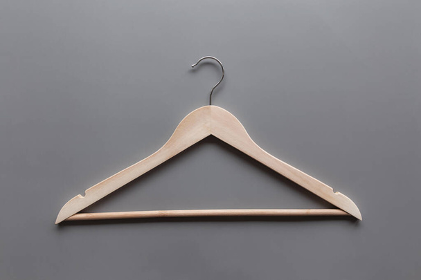 Μαύρη Παρασκευή ή ενδυμάτων έννοια της βιομηχανίας σε γκρι φόντο επίπεδη θέσει με ένα μεμονωμένο ξύλινο κρεμάστρα ρούχα - Φωτογραφία, εικόνα