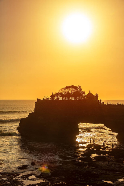 Silhouette of Pura Batu Bolong in golden sunset it the traditional Balinese temple located on a rocky, in the Tanah Lot area, Bali, Indonesia. It a Hindu Temple on the Beatiful Rock - Photo, Image