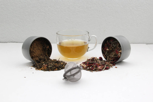 Strumenti per la preparazione del tè: infusore, tazza di vetro, erba secca, cucchiaio per il relax e la cura delle malattie - Foto, immagini