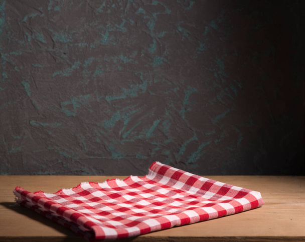 Empty wooden deck with table cloth, napkin over wall background - Fotó, kép