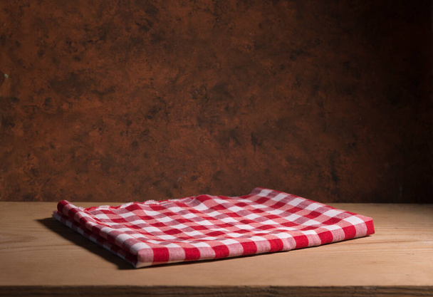 Empty wooden deck with table cloth, napkin over wall background - Foto, afbeelding