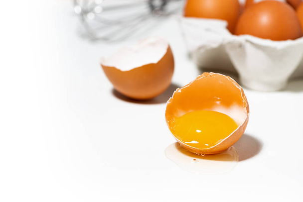 broken chicken egg on white background, baking ingredients, closeup - Фото, зображення