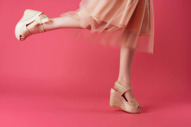 женские ноги в обуви платье обрезанный вид розовый фон позируя - Фото, изображение