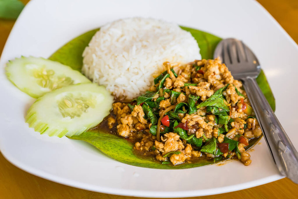 Revuelva la albahaca tailandesa frita con cerdo picado y chile sobre el arroz rematado. - Foto, Imagen