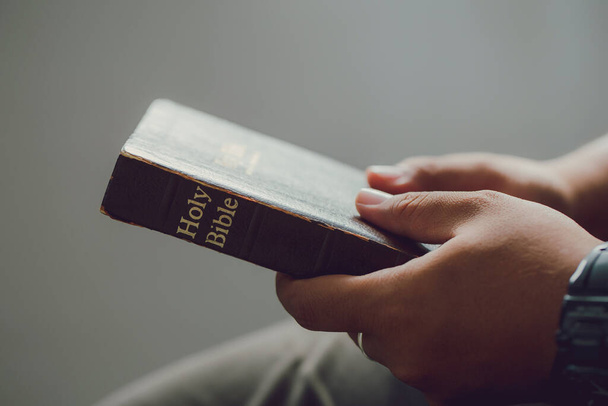 Κοντινό πλάνο σε έναν άνθρωπο χέρια κρατώντας μια Αγία Γραφή.πιστεύω έννοια - Φωτογραφία, εικόνα