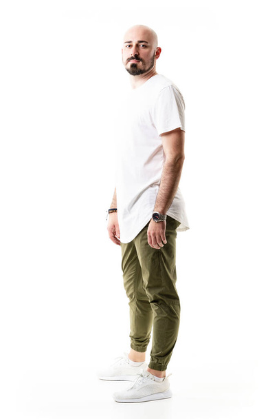 Casual moderno moderno calvo barbudo hipster posando con los brazos abajo. Longitud total del cuerpo aislado sobre fondo blanco - Foto, Imagen
