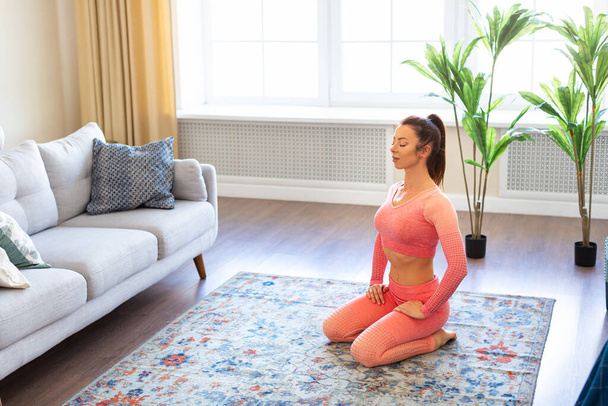 Healthy lifestyle concept - woman meditating in home interior. - Fotó, kép