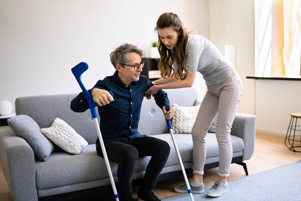 Woman Helping Injured Handicapped Man With Crutches - Valokuva, kuva