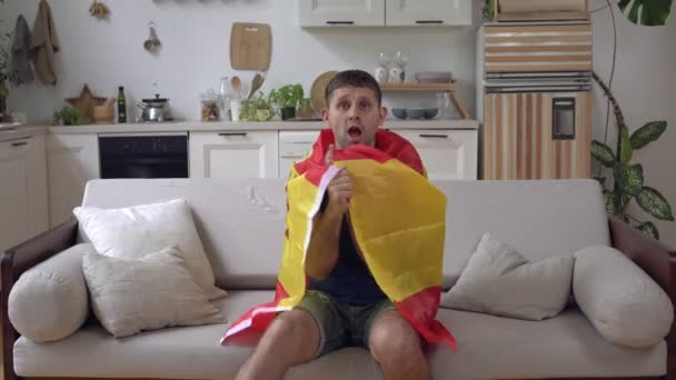 Tifoso spagnolo di calcio o sport maschile a casa con la bandiera della Spagna - Filmati, video